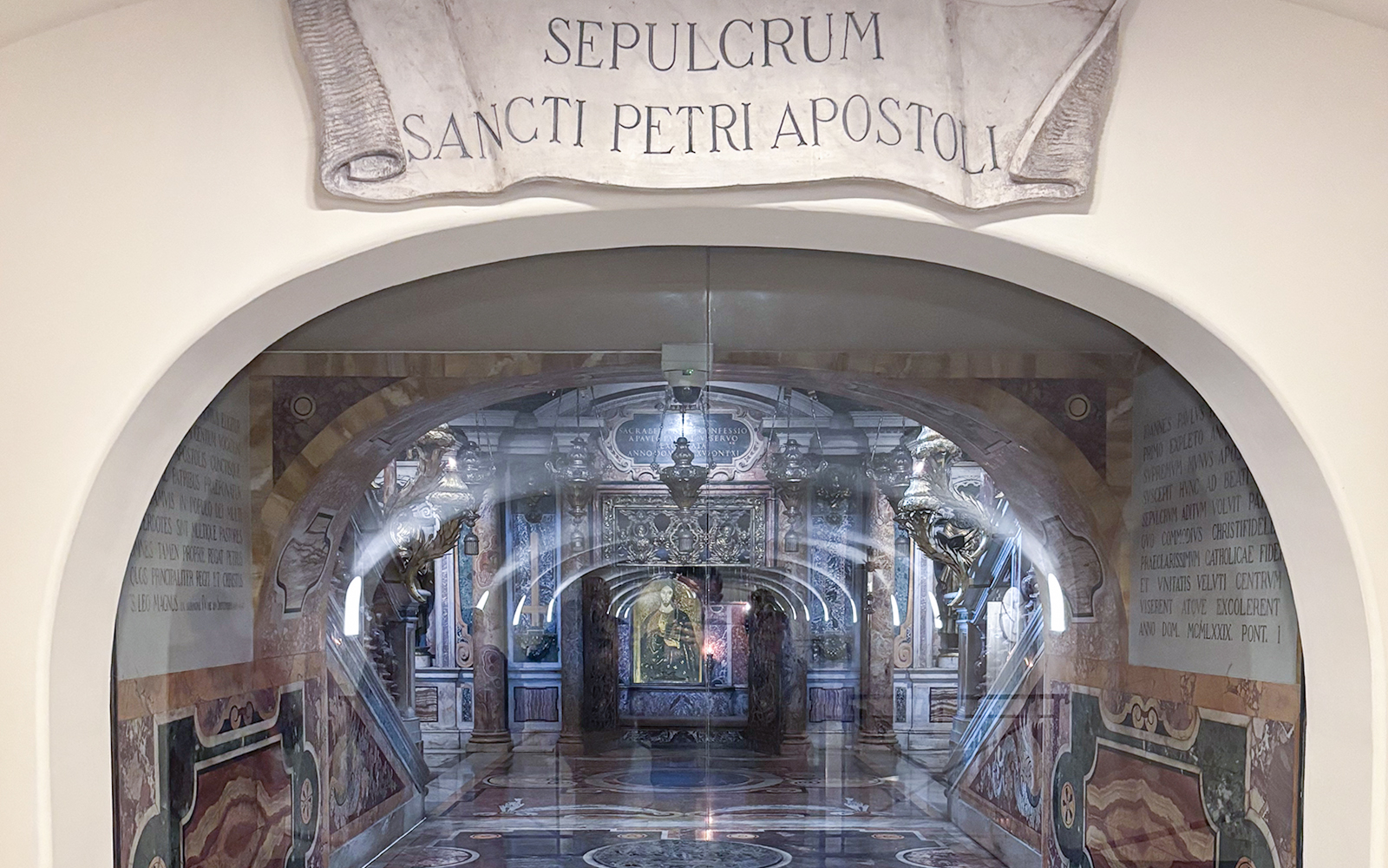Tomb of St. Peter in St. Peter's Basilica, Vatican City, with ornate decorations and Latin inscription.
