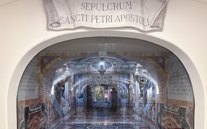 Tomb of St. Peter in St. Peter's Basilica, Vatican City, with ornate decorations and Latin inscription.