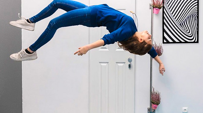 Person appearing to float sideways in a room at the Museum of Illusions.