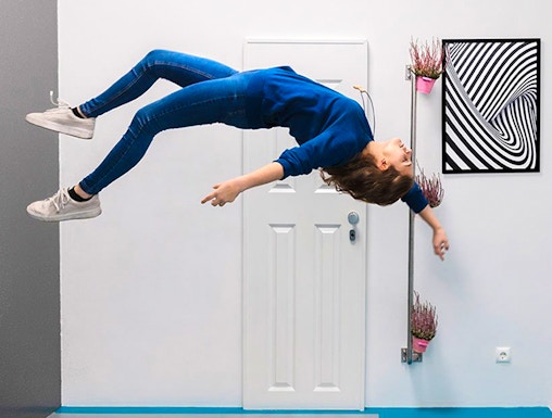 Person appearing to float sideways in a room at the Museum of Illusions.