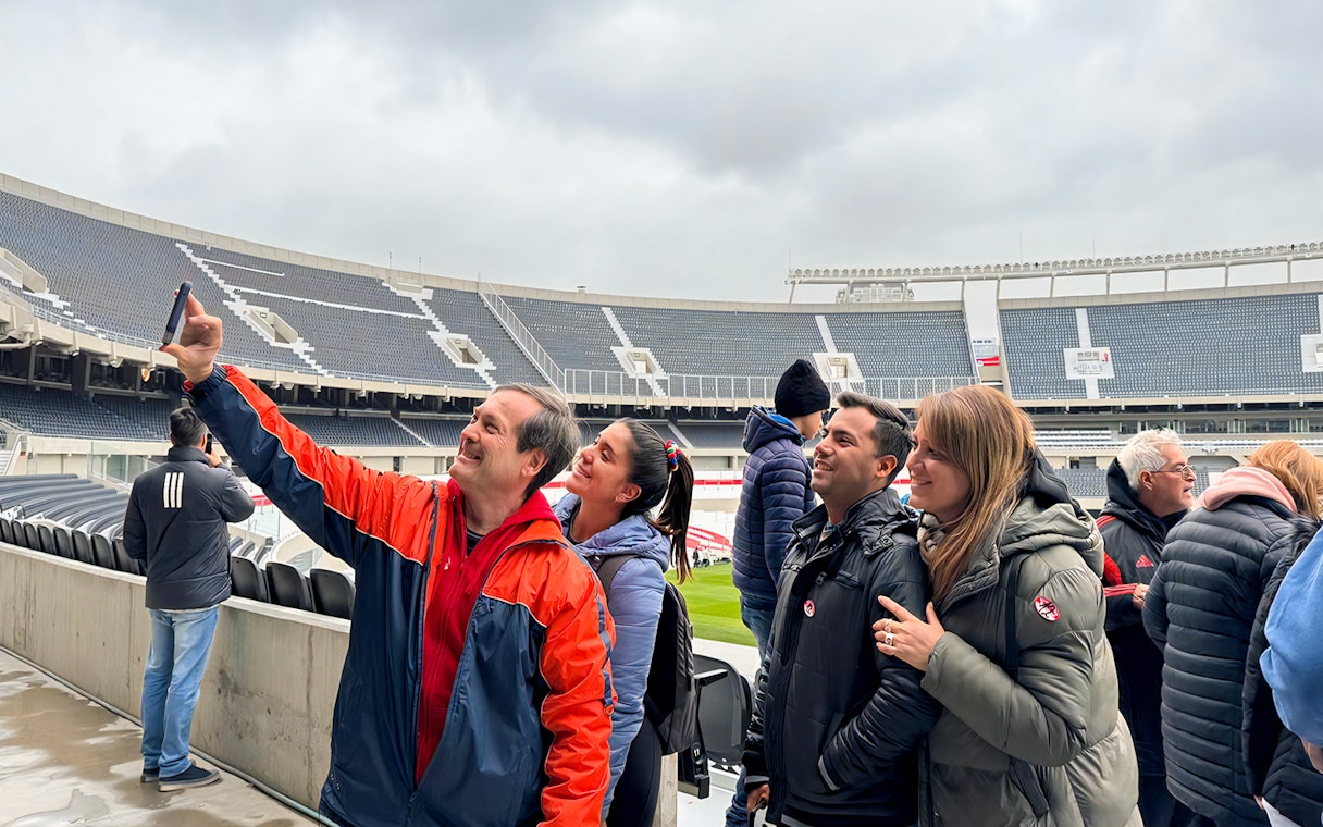 Tourists with guide taking photos at La Bombonera stadium in Buenos Aires.