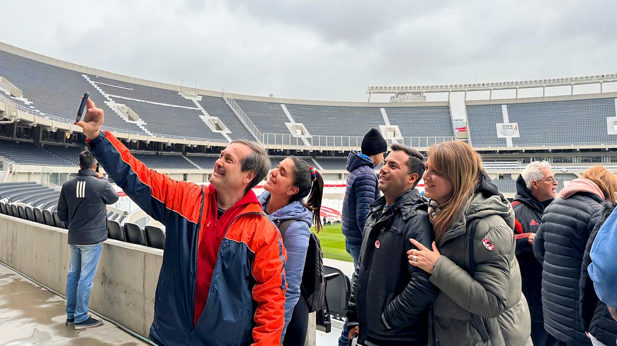 Tourist with guide taking photos at La Bombonera stadium, Buenos Aires.