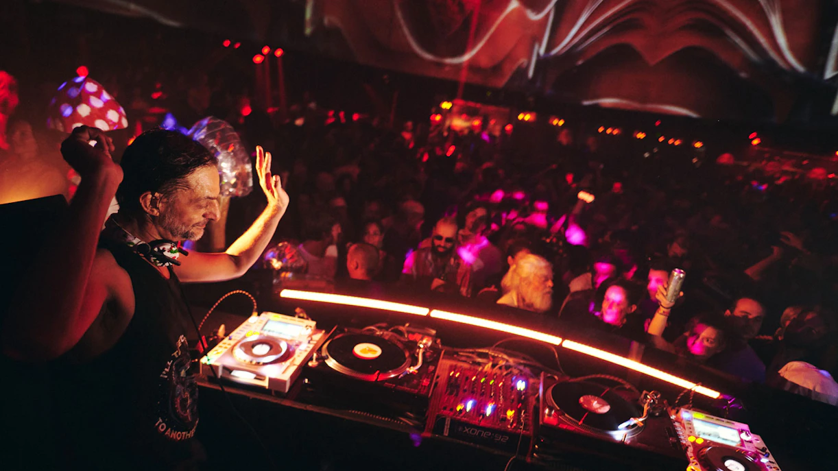 DJ performing at Club Chinois with vibrant crowd and colorful lights.