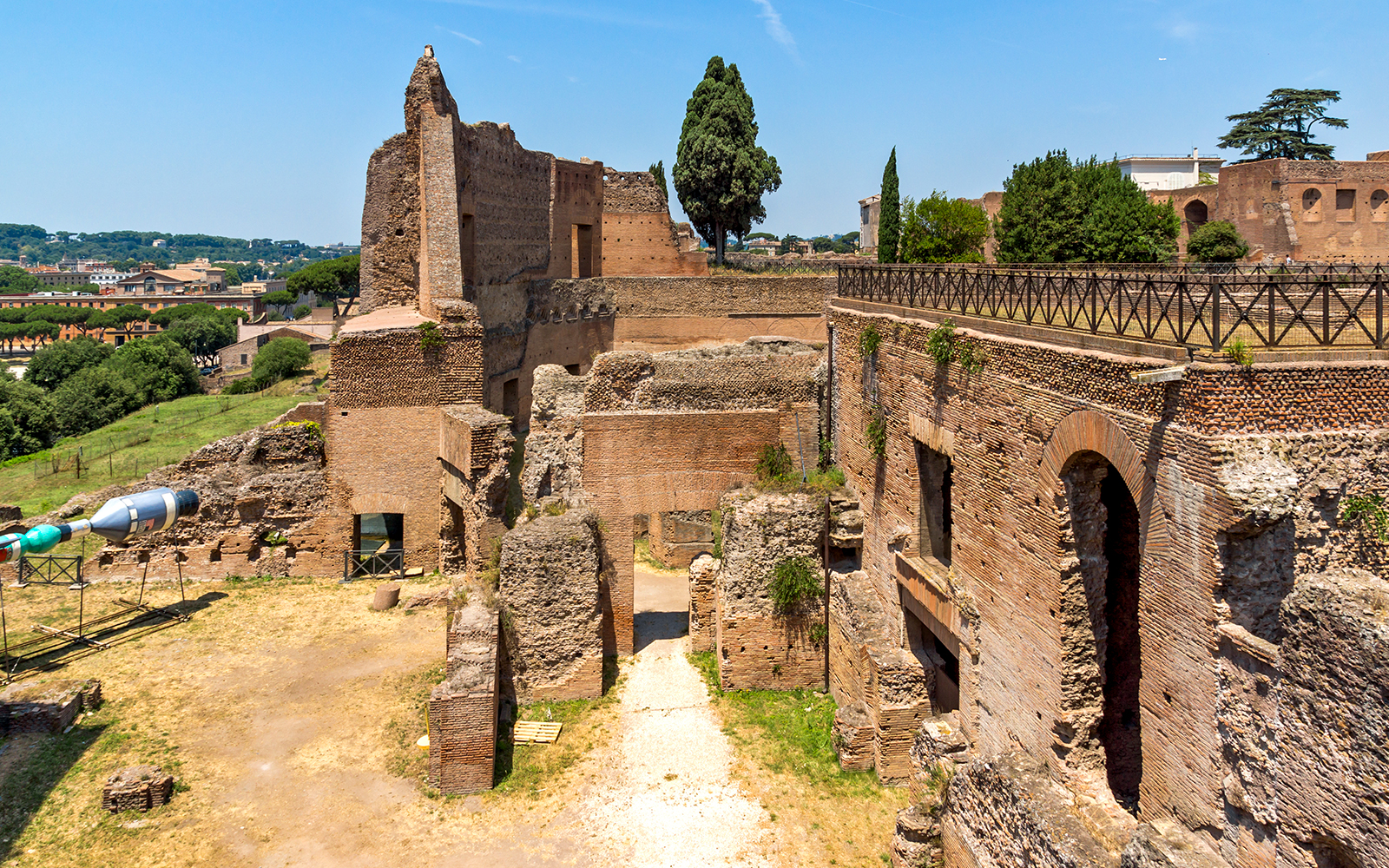 Roman Forum ruins with ancient brick structures and Palatine Hill in Rome.