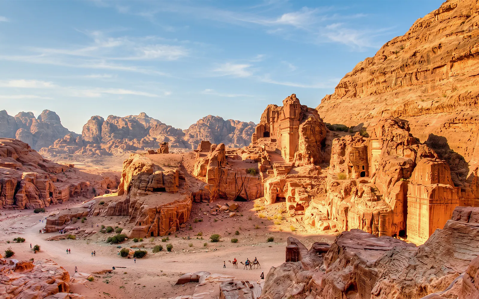 Petra's ancient rock-cut architecture with tourists exploring the site in Jordan.