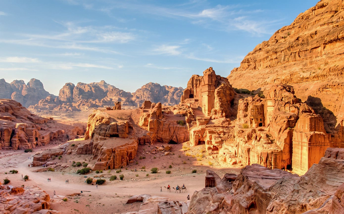 Petra's ancient rock-cut architecture with tourists exploring the site in Jordan.