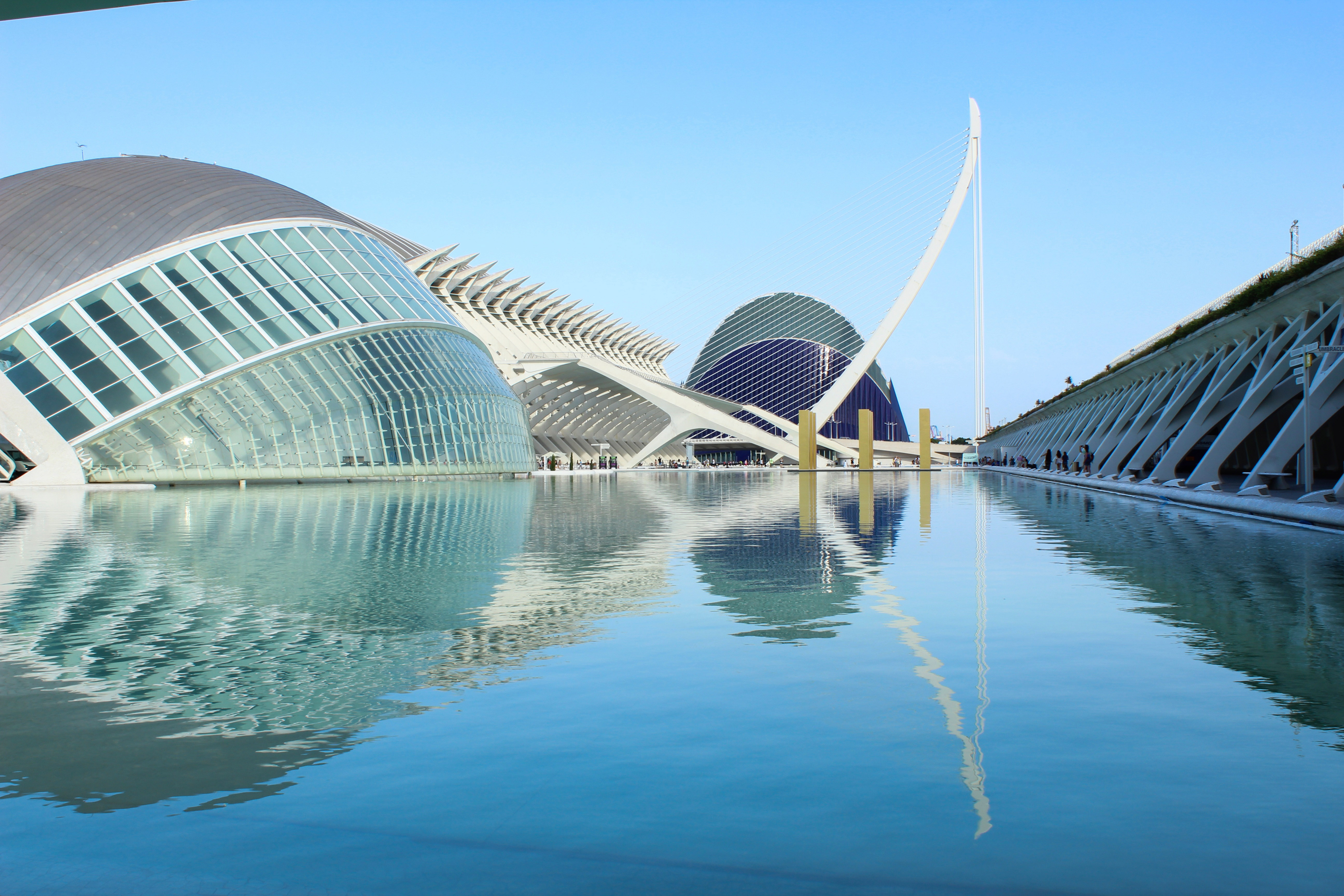 Hemisferic building in Valencia, Spain, reflecting in water at sunset.