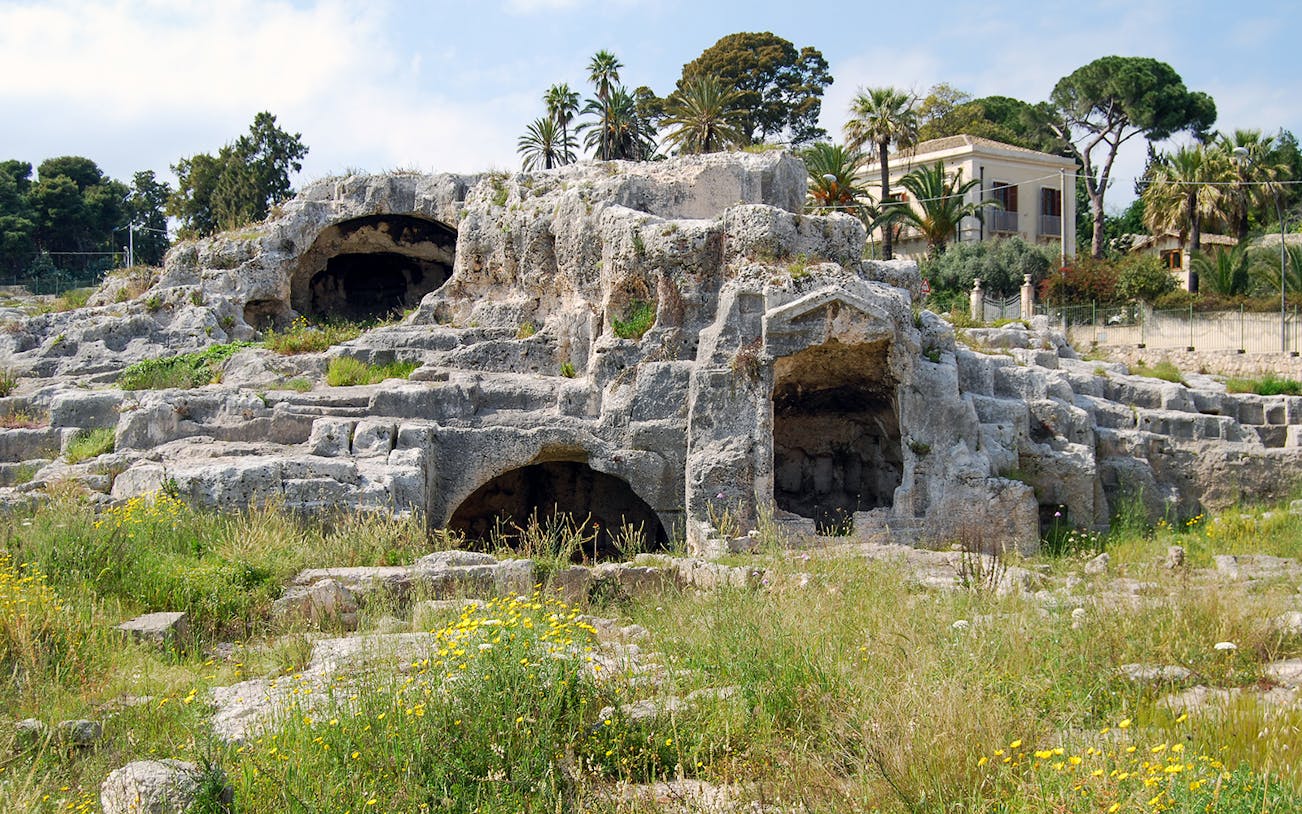 Neapolis Archaeological Park ruins with caves and greenery, Syracuse, Italy.
