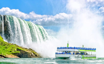 Tour boat near Niagara Falls USA with mist and cascading water.