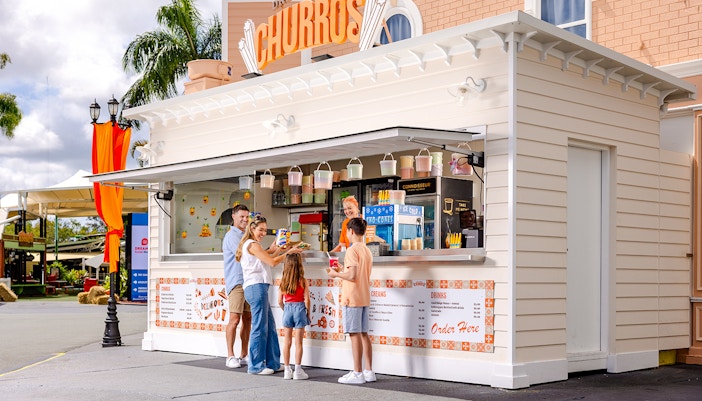 Churro stand at Dreamworld, Gold Coast, with visitors enjoying dining experience.