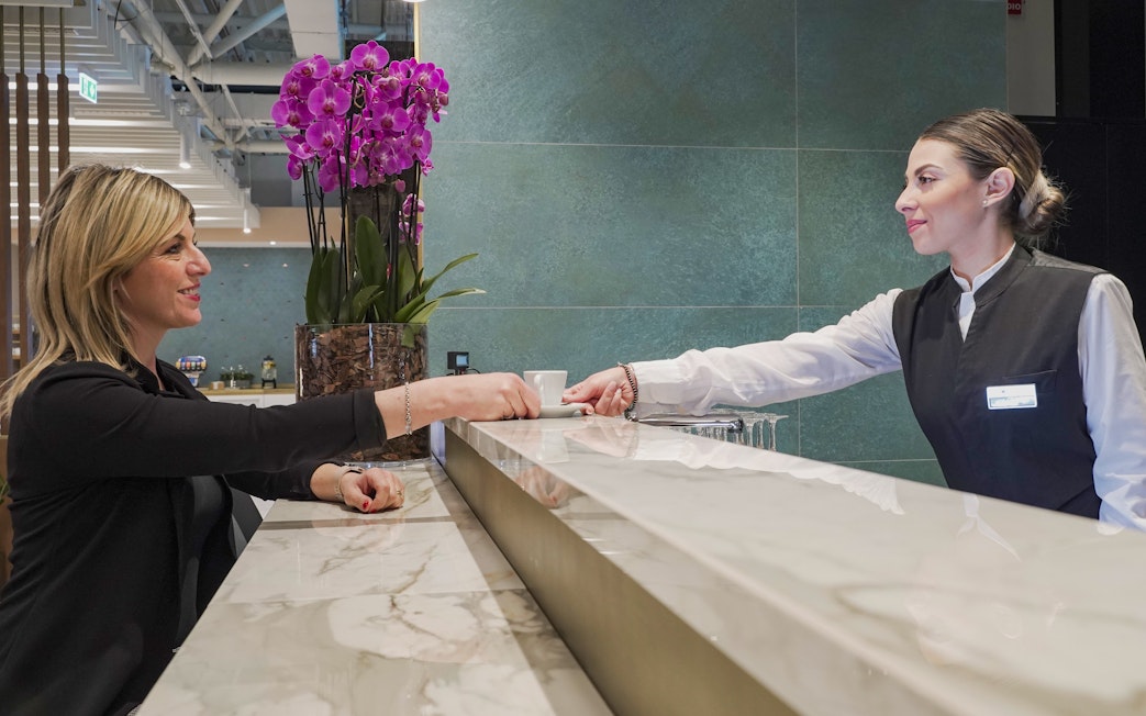 Guest checking in at Plaza Premium First Lounge, Rome Fiumicino Airport Terminal 1.