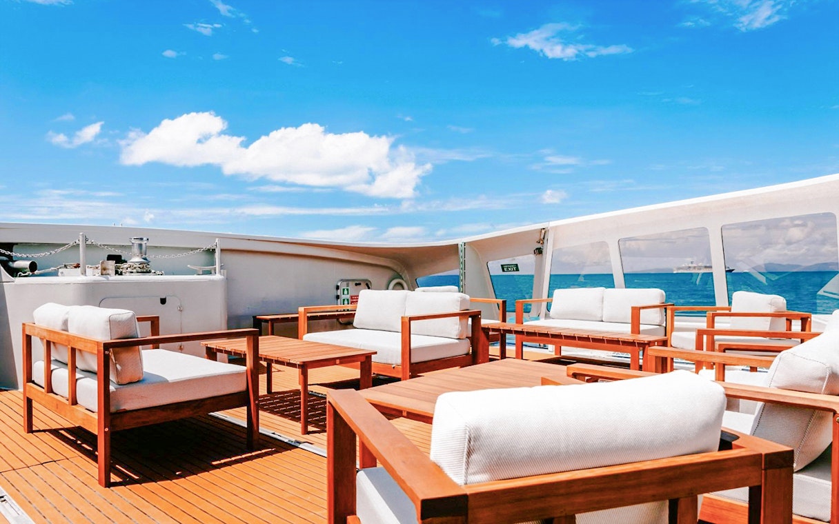 Outdoor seating area on a boat deck during ZigZag Whitsundays Day Tour.