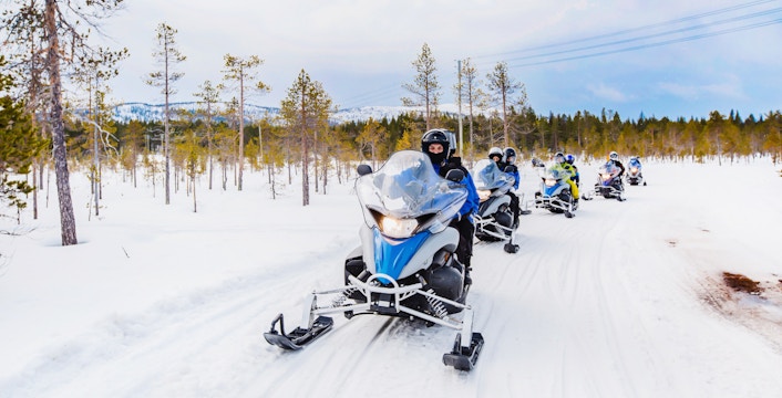 Visitors riding snowmobiles through snowy Zakopane landscape, Poland.