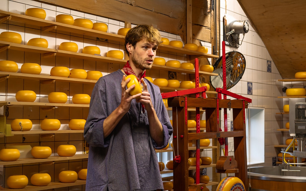 Cheese maker explaining cheese production process in a Dutch cheese factory.