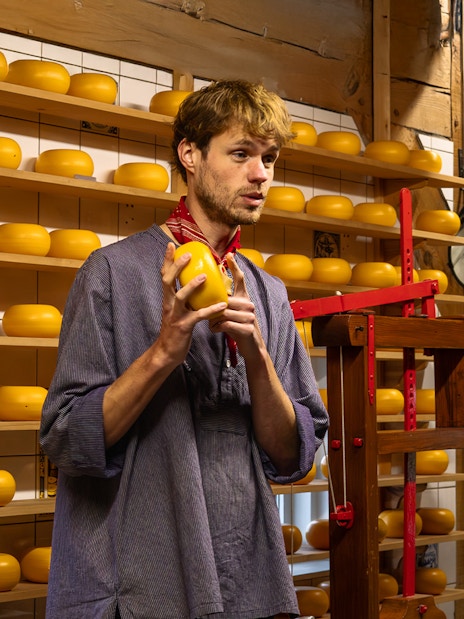 Cheese maker explaining cheese production process in a Dutch cheese factory.
