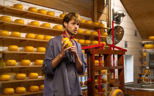 Cheese maker explaining cheese production process in a Dutch cheese factory.