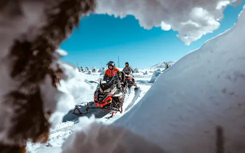 Snowmobilers riding through snowy landscape in Rovaniemi.