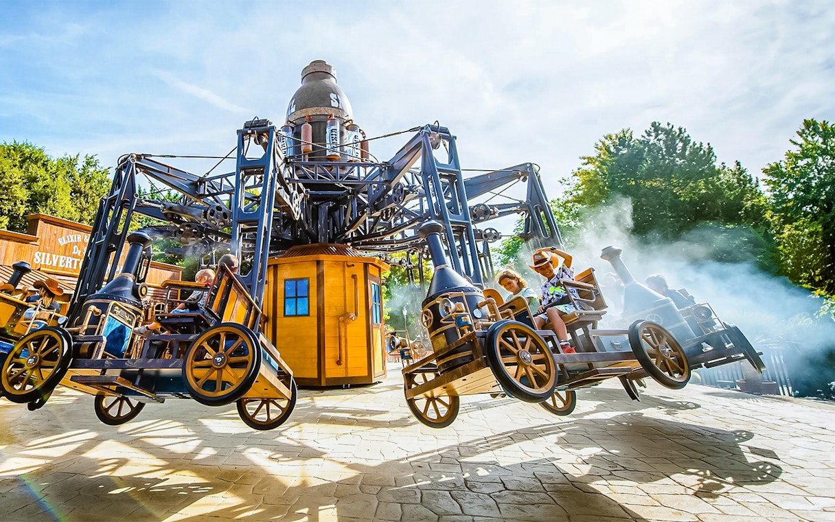 Tourists on the Silverton ride at Walibi Belgium, enjoying the steampunk-themed attraction.