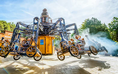 Tourists on the Silverton ride at Walibi Belgium, enjoying the steampunk-themed attraction.