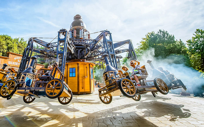 Tourists on the Silverton ride at Walibi Belgium, enjoying the steampunk-themed attraction.