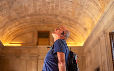 Visitor with audio guide admiring the Roman Pantheon's interior architecture.