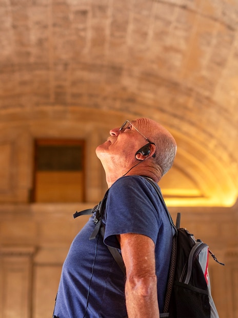 Visitor with audio guide admiring the Roman Pantheon's interior architecture.