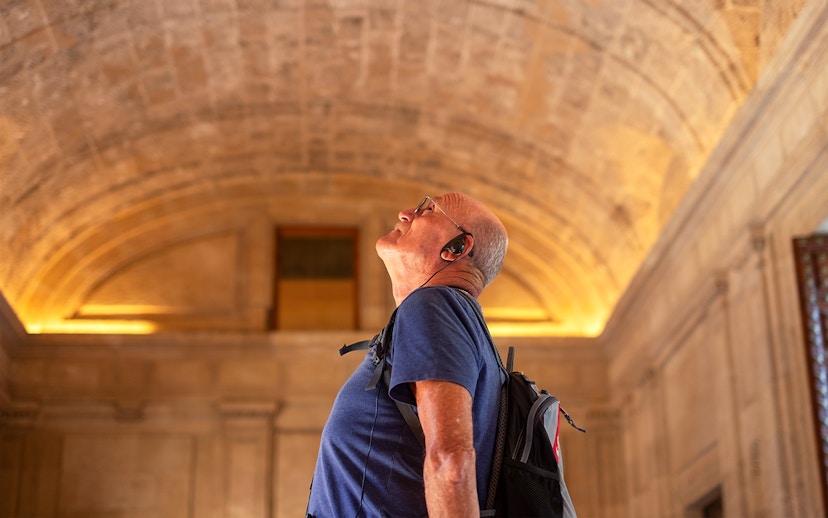 Visitor with audio guide admiring the Roman Pantheon's interior architecture.