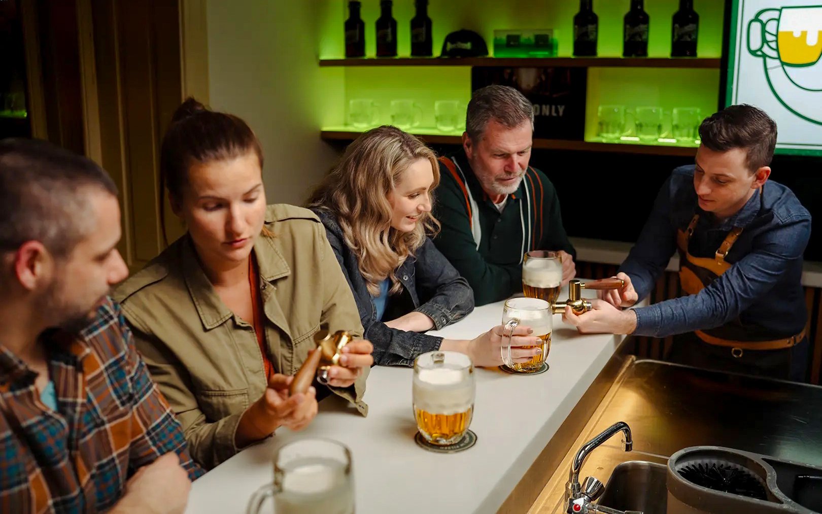 Prague Pilsner Urquell Experience with group learning beer tapping at bar.