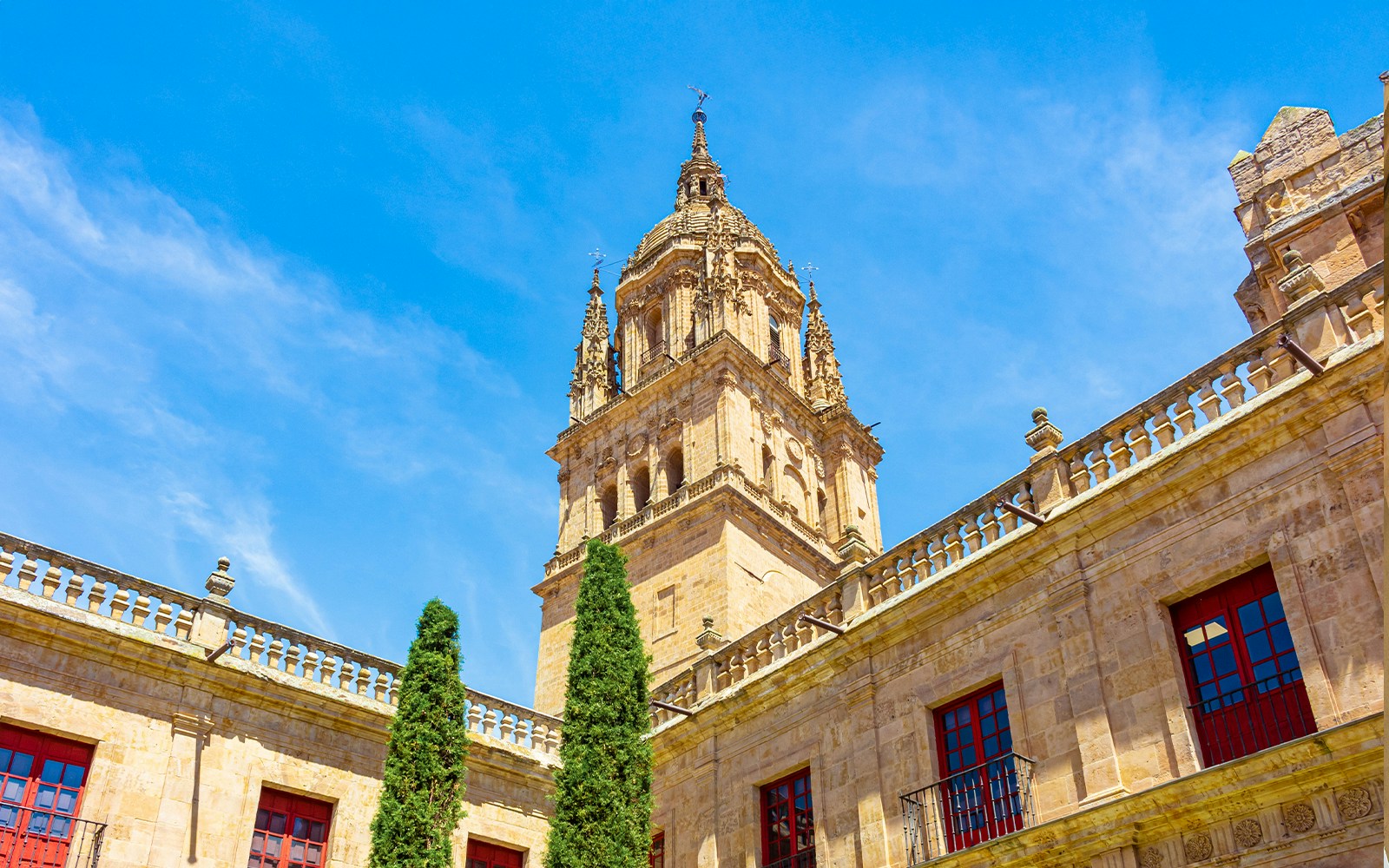 Bell tower of Salamanca Cathedral against blue sky.