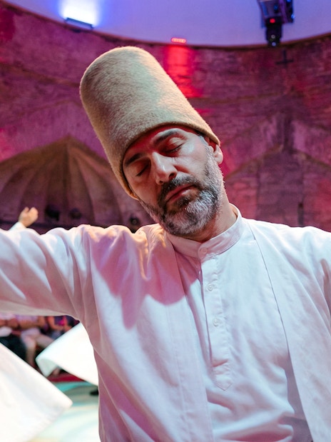 Whirling Dervish performing in traditional attire during a show.
