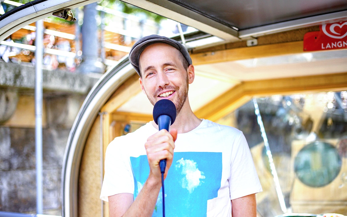Tour guide speaking into a microphone on a river cruise boat.