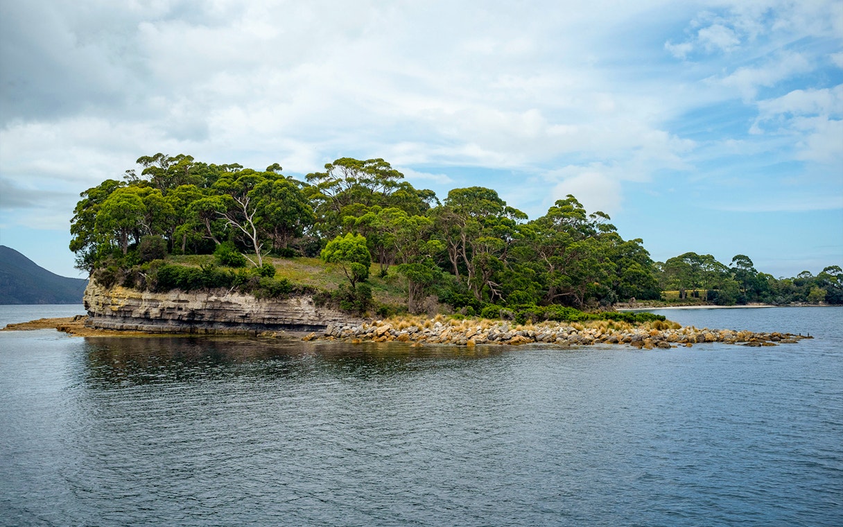 Port Arthur coastal landscape with rocky shoreline and lush greenery.