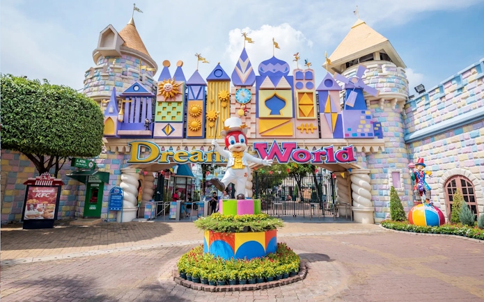 Dream World Bangkok entrance with colorful castle facade and character statue.