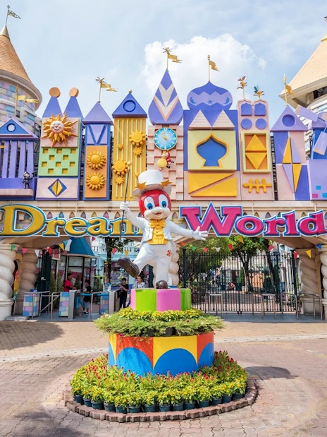 Dream World Bangkok entrance with colorful castle facade and character statue.
