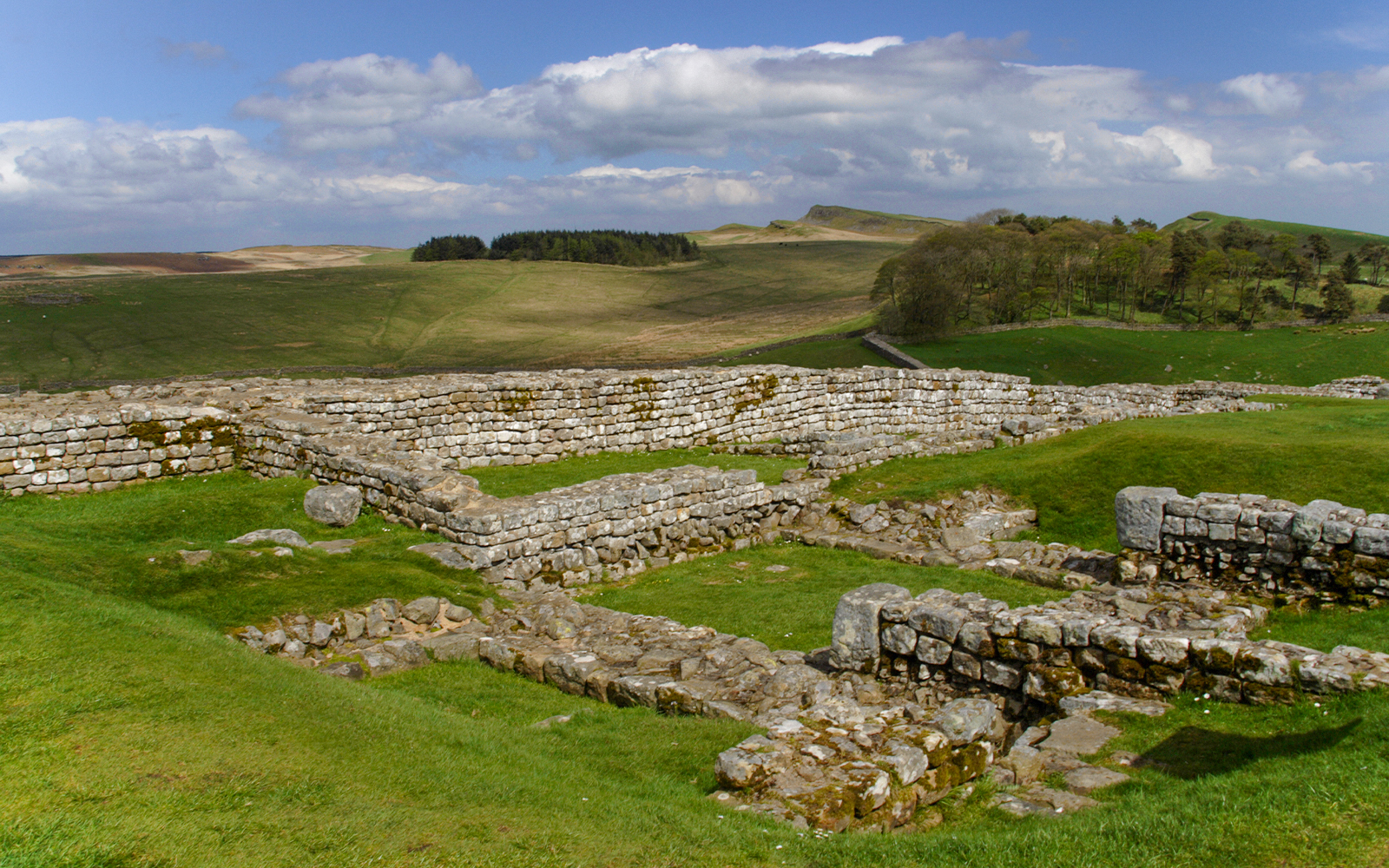 Housesteads Roman Fort ruins on Hadrian's Wall, Northumberland, England, showcasing ancient stone structures.