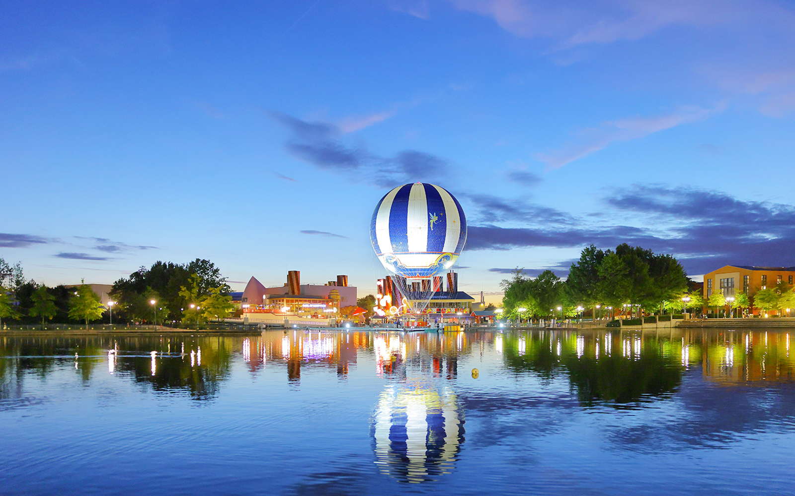Ballon Panoramagique floating over a lake at dusk in Paris, France.