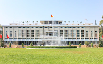 Independence Palace in Saigon, Vietnam with fountain and green lawn.
