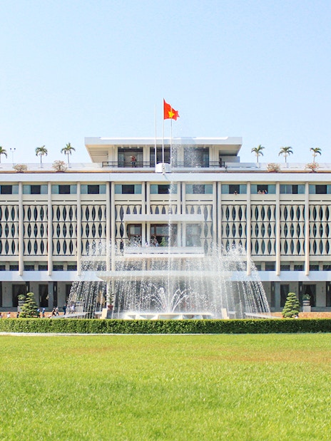 Independence Palace in Saigon, Vietnam with fountain and green lawn.