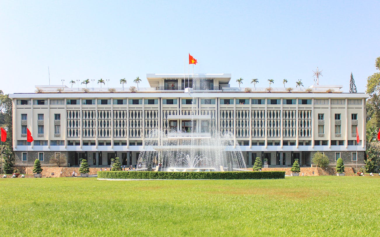 Independence Palace in Saigon, Vietnam with fountain and green lawn.