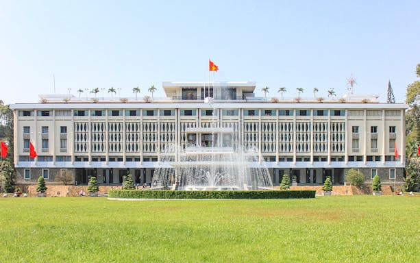 Independence Palace in Saigon, Vietnam with fountain and green lawn.