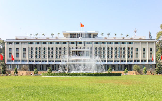 Independence Palace in Saigon, Vietnam with fountain and green lawn.