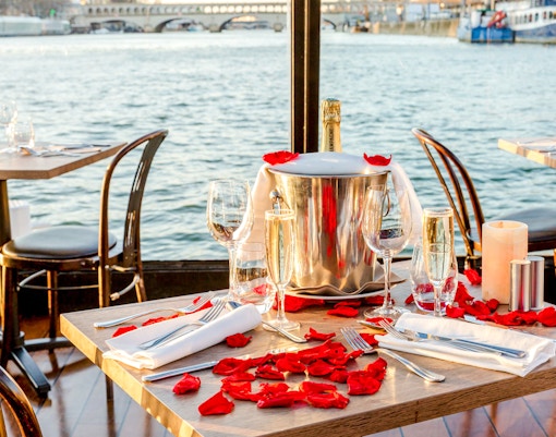 Table set with champagne and rose petals on Seine River cruise.