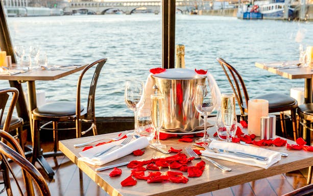 Table set with champagne and rose petals on Seine River cruise.