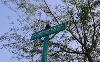 Street sign for Jl. Marga Utama with tree branches, part of Colonial Heritage Walking Tour, Yogyakarta.
