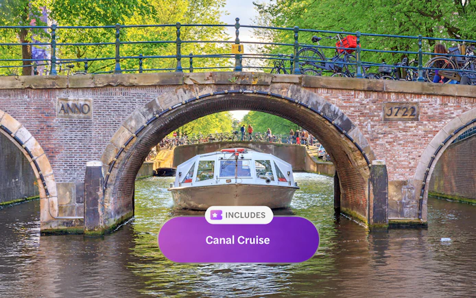 Canal boat passing under a historic bridge in Amsterdam.