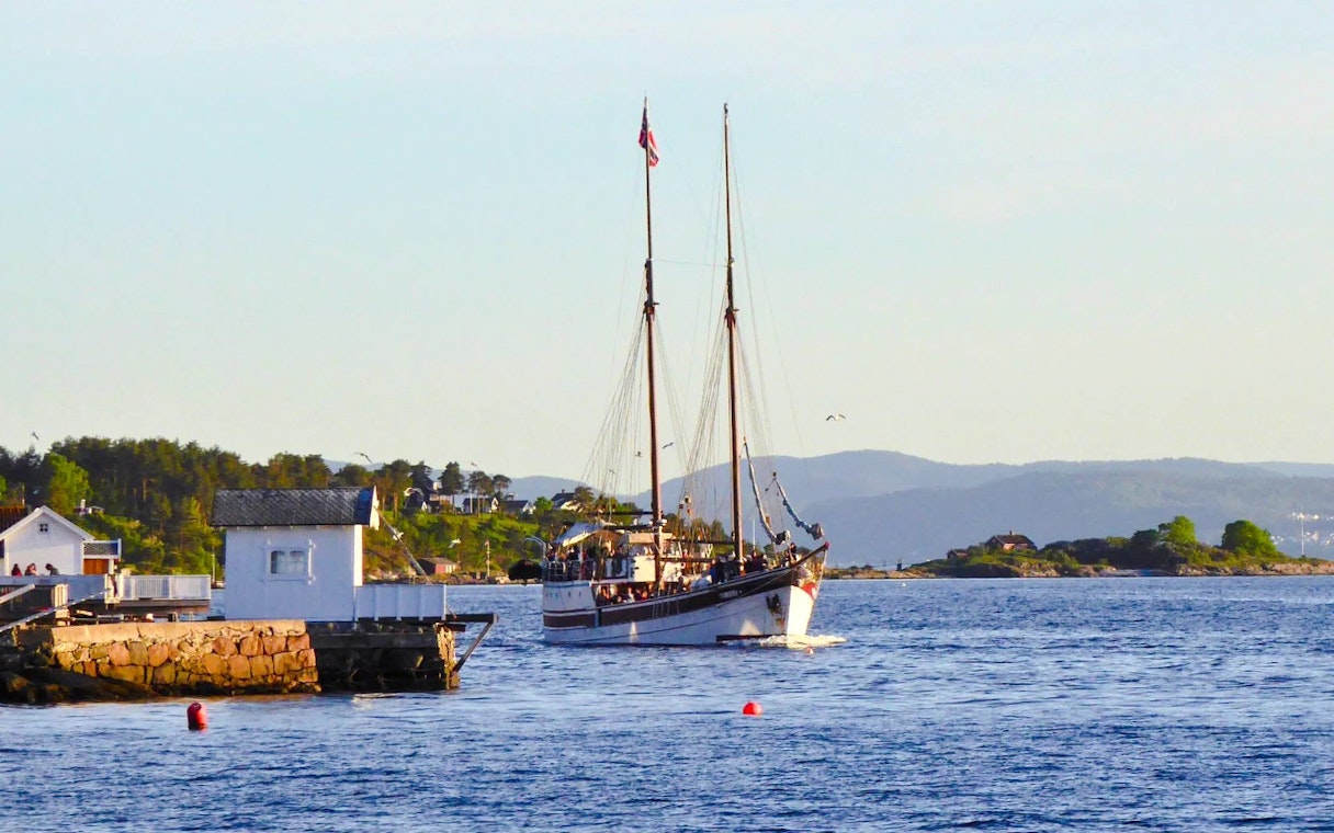 Sailing ship on a fjord sightseeing cruise near Oslo, with coastal scenery in the background.