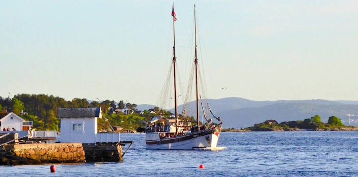 Sailing ship on a fjord sightseeing cruise near Oslo, with coastal scenery in the background.