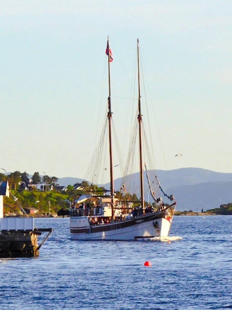 Sailing ship on a fjord sightseeing cruise near Oslo, with coastal scenery in the background.