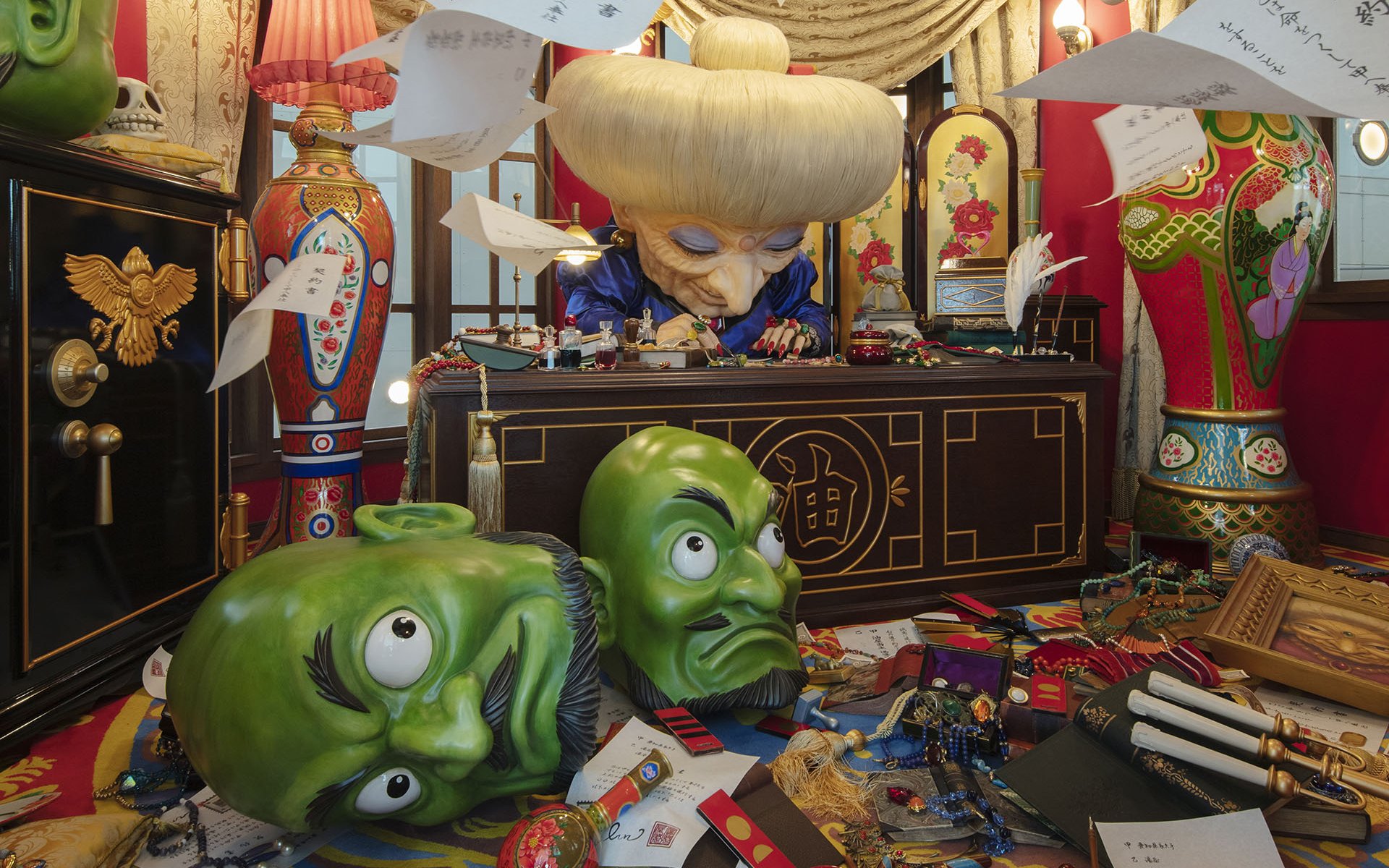 Director's Room with ornate desk, large green masks, and colorful decor.