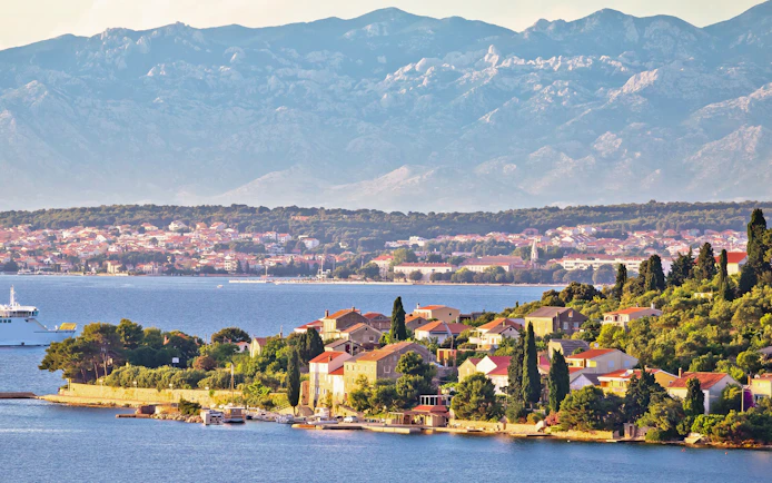 Small island of Osljak with view of Zadar city and mountains in the Zadar archipelago.